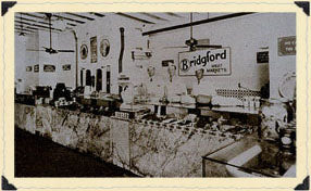 Vintage black and white photo of workers behind the counter at a Bridgford Meat Markets store.
