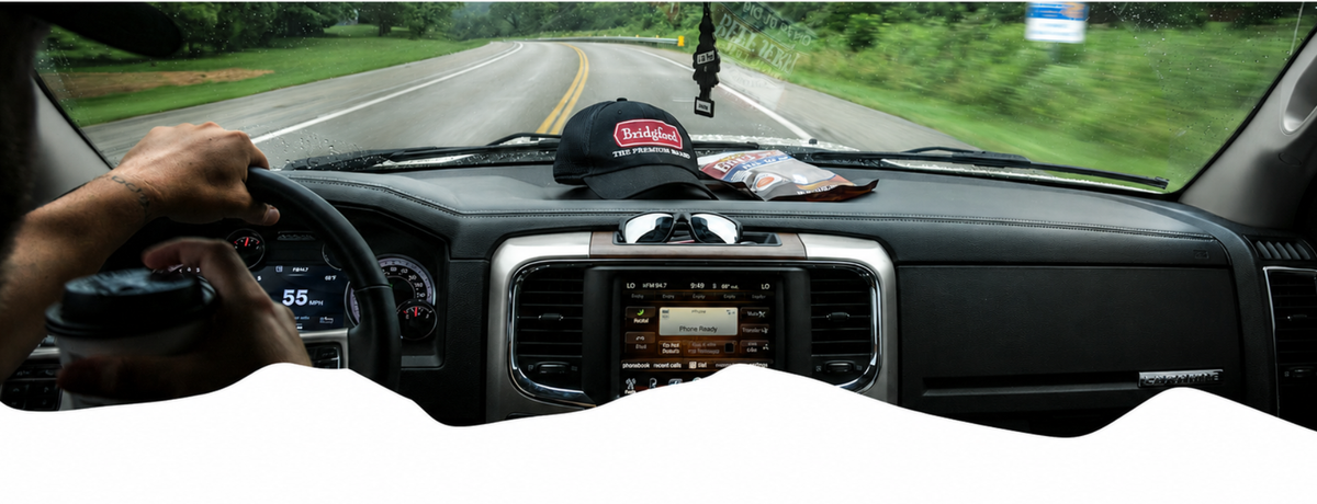 Bridgford hat and snack bag on a truck dashboard while driving